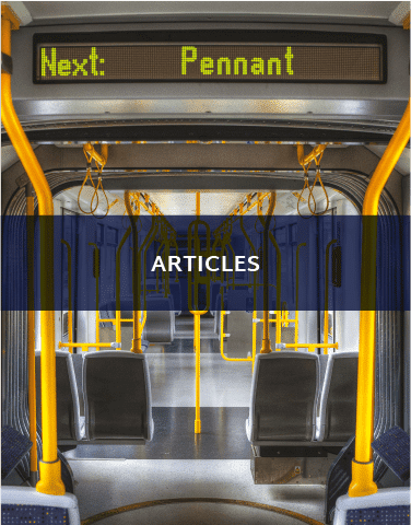 The inside of a train. There is a sign in the train that implies the next stop is Pennant. There is a blue banner that says "Articles" on it