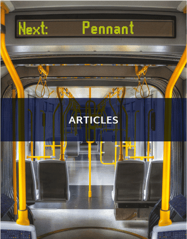 The inside of a train. There is a sign in the train that implies the next stop is Pennant. There is a blue banner that says "Articles" on it